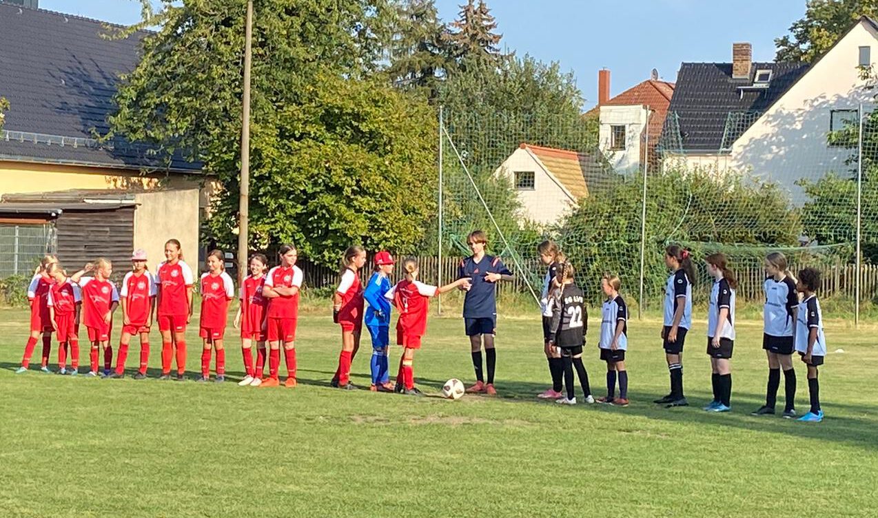 Mädchenteams stehen auf einem Fußballplatz